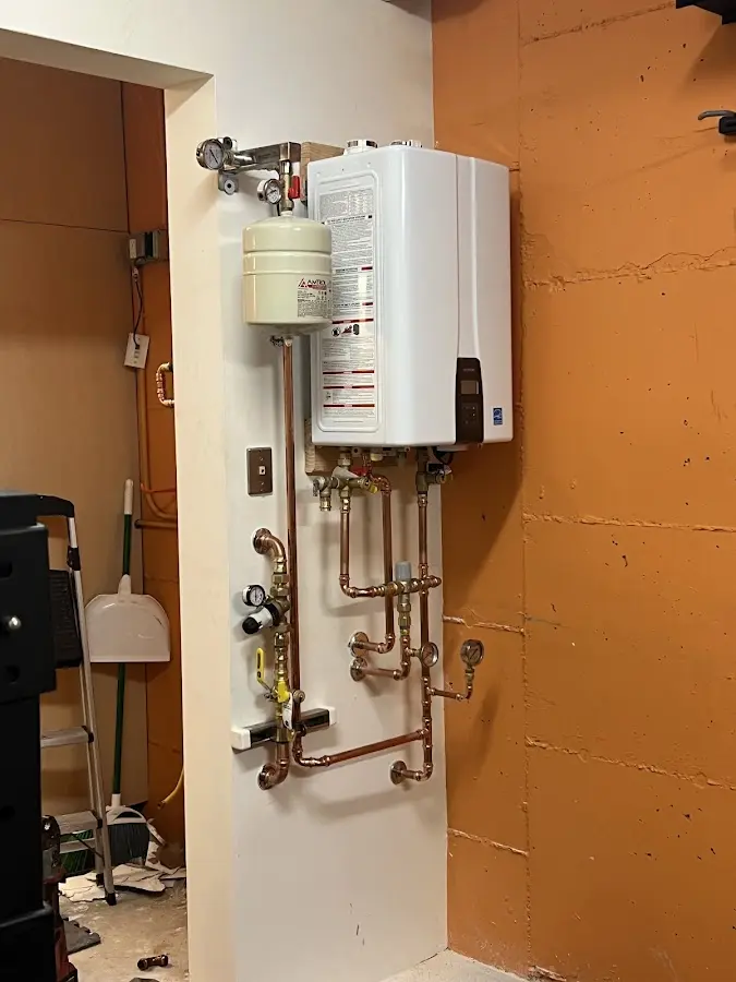 Plumbing technician inspecting water heater connections in Farmingdale